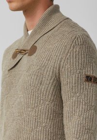 Beżowy sweter dziany z kołnierzem szala, z zapięciem na drewniany toggle i teksturowanym wzorem, z logotypem na rękawie.