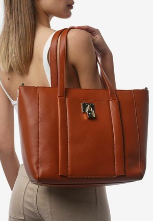 Borsa a tracolla in pelle marrone con un design strutturato, dotata di due manici e un accento di chiusura dorata sulla tasca frontale. Texture liscia.