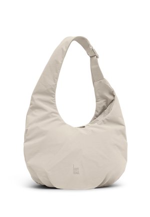Beigenvärinen, puolikuun muotoinen olkalaukku, jossa leveä olkahihna ja hienovarainen "GOT BAG."-logo etuosan keskellä.