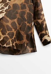 Chemise à manches longues imprimée girafe marron et beige avec poignets à boutons et boutons sur le devant, présentée de la taille jusqu'à la manche.