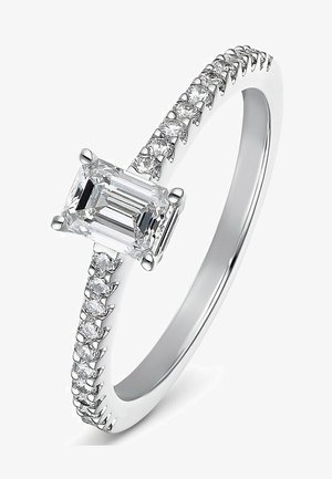 White gold ring featuring an emerald-cut center stone with a prong setting, surrounded by smaller round diamonds along the band.