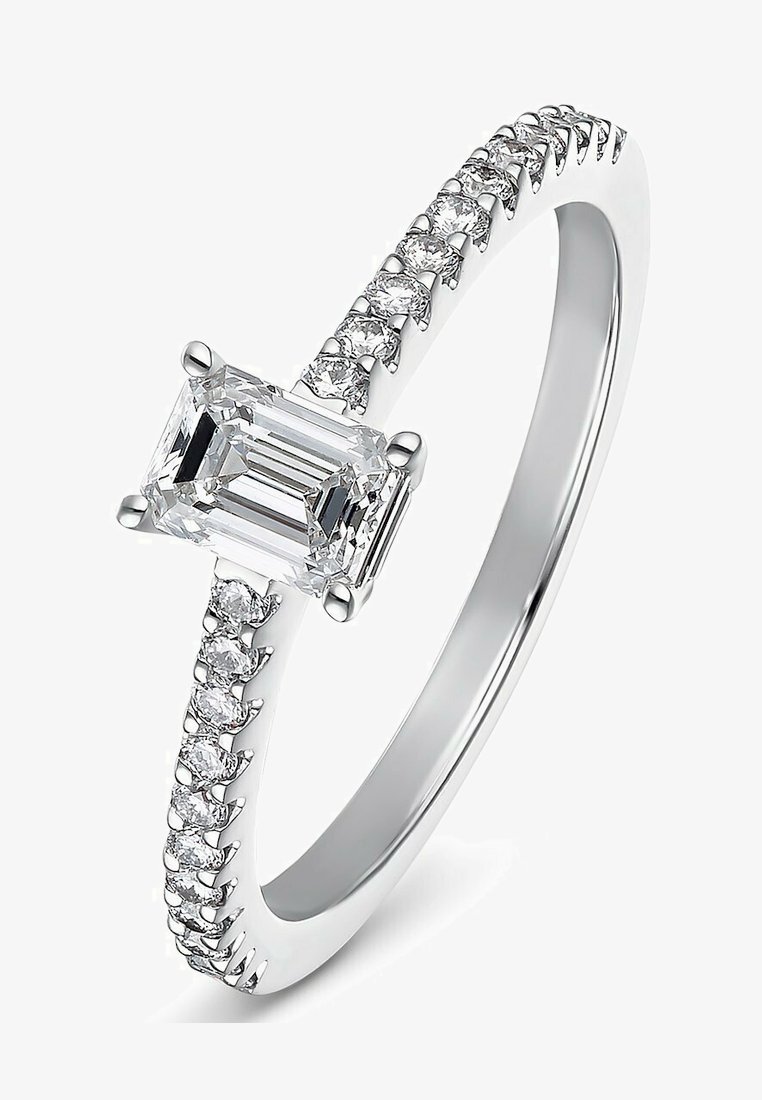 White gold ring featuring an emerald-cut center stone with a prong setting, surrounded by smaller round diamonds along the band.