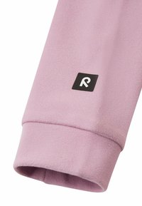 Manica in pile rosa con un logo quadrato nero raffigurante la lettera "R" in bianco. Texture morbida con cuciture visibili e orlo a coste.