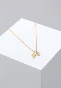 Gold chain necklace featuring a leaf-shaped pendant and a round gemstone pendant with a textured surface. Urgent materials with a delicate design.