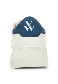 Witte sneaker met een marineblauw suède hielpatch, een gestructureerde rubberen zool en een logo in het wit. Beschikt over een bovenwerk van glad leer met stikseldetails.