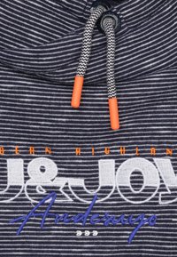 Marine gestreepte stoffen hoodie met oranje trekkoorden en witte en blauwe geborduurde logotekst, met een zachte, gestructureerde afwerking.
