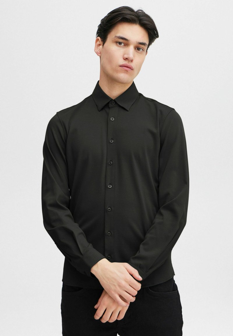 Black long-sleeve button-up shirt with a collar, made from smooth fabric, featuring front buttons and fitted sleeves.