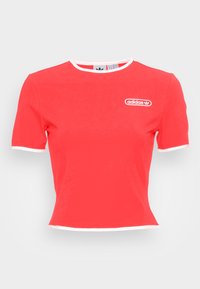 Červené tričko s krátkým rukávem a kulatým výstřihem, s bílým lemem a logem Adidas na hrudi. Vyrobeno z hladké tkaniny.