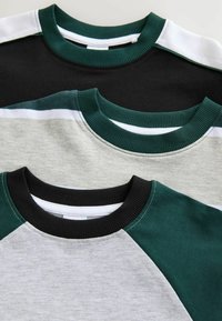 Drie T-shirts met ronde hals: zwart, grijs, en een mix van grijs en groen. Elk shirt heeft contrasterende geribbelde kragen en mouwaccenten.