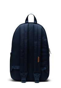 Zaino in tessuto navy con spallacci imbottiti, maniglia superiore e un piccolo dettaglio in pelle. Texture liscia con forma arrotondata e zip singola.