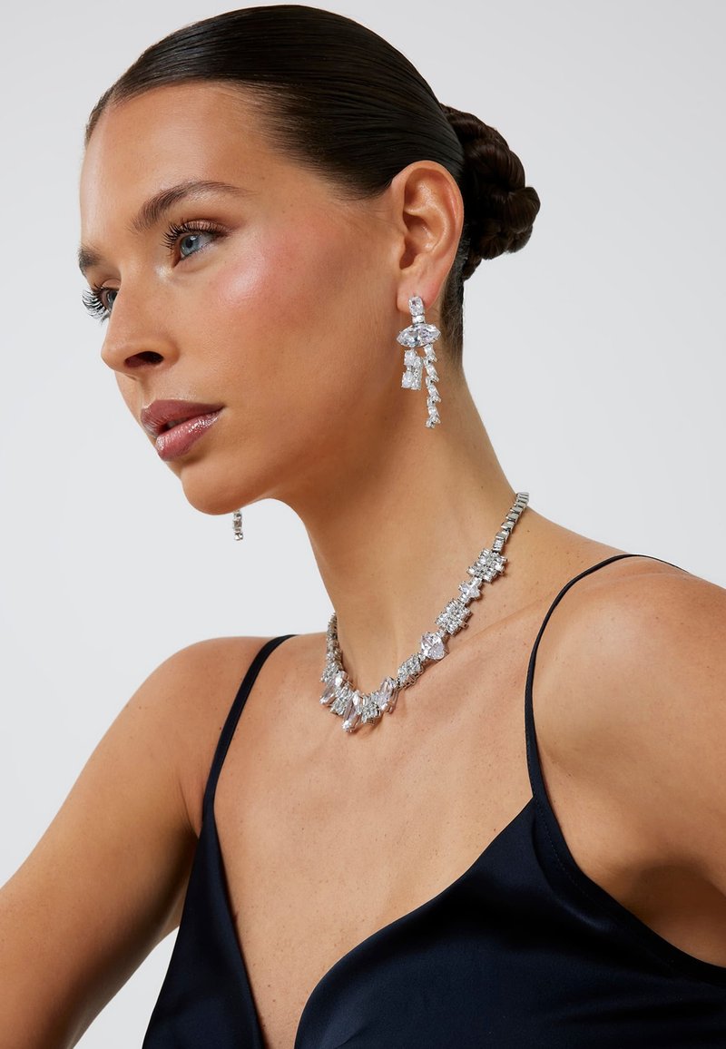 Silberschmuck-Set mit einer Perlenkette und Kronleuchter-Ohrringen, verziert mit klaren Kristallen in verschiedenen geometrischen Formen.