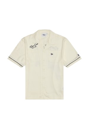 Kremfarvet kortærmet skjorte med knapper, med teksten "New Era Since 1920" på brystet, to forlommer og sort kant på ærmerne.