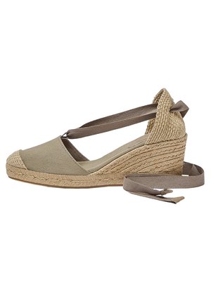 Espadrille compensée beige avec semelle en jute tissé et liens à nouer autour de la cheville, dotée d'un bout fermé et d'un contrefort de talon texturé.