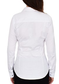 White long-sleeve shirt with a classic collar, fitted shape, curved hem, and button accents at the cuffs. Smooth fabric texture.