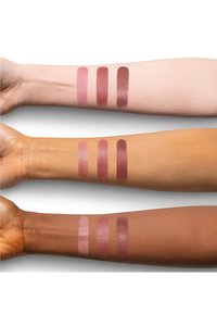 Drei Arme mit Lippenfarbmustern: helles Pink, Mauve und tiefes Beerenton auf hellen bis dunklen Hauttönen. Die Muster zeigen unterschiedliche Deckkraft und Finish.