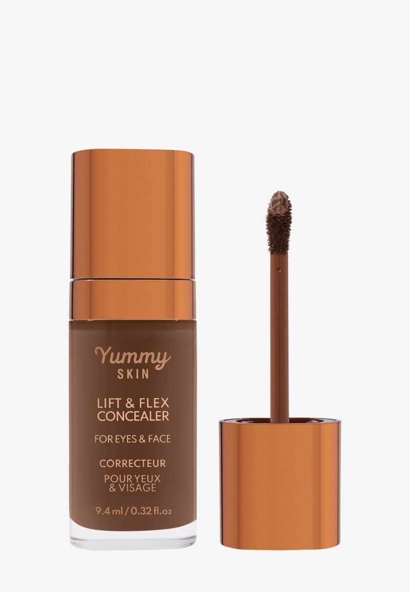 Correcteur Lift & Flex dans un flacon en verre transparent avec un liquide brun. Le bouchon et l'applicateur sont de couleur orange métallique, dotés un applicateur en éponge.