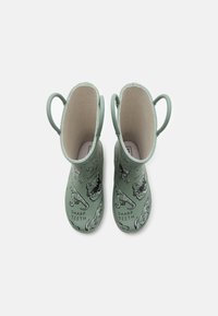 Bottes de pluie vertes pour enfants avec des illustrations de dinosaures et le texte "DENTS AFFÛTÉES", dotées de poignées de tirage de chaque côté.