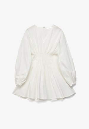 Balta ilgomis rankovėmis suknelė su V formos iškirpte, suveržta juosmeniu, platėjančia sijono dalimi, elastinėmis rankogalių apykaklėmis ir užtrauktuku nugaros pusėje.