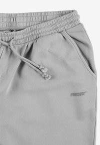 Szare bawełniane spodnie dresowe z elastycznym pasem, sznurkiem, bocznymi kieszeniami oraz małym logo "PROSTO" w ciemniejszym odcieniu szarości.