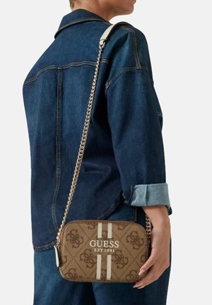Borsa a tracolla monogramma marrone con dettagli a strisce bianche e tracolla in catena. Tessuto testurizzato con il logo "GUESS EST 1981" ben visibile.