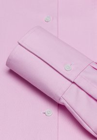 Camicia da uomo rosa in tessuto testurizzato con polsini ripiegati, bottoni bianchi e colletto liscio, che mette in risalto il suo design classico.