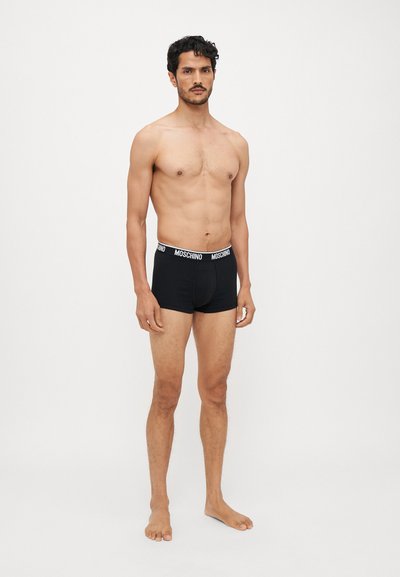 Black cotton boxer briefs with a white Moschino logo on the elastic waistband. The fabric has a smooth texture and a fitted design.
