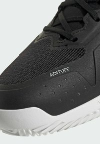 Czarne buty sportowe z teksturowaną siateczką u góry, gumową podeszwą, oznaczeniem ADITUFF oraz białymi akcentami na pięcie i podeszwie.
