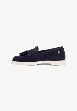 Marineblå loafers i ruskind med duskdetalje, hvid gummisål og diskret branding på siden. Klassisk, fladt design.