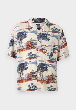 Chemise beige à manches courtes avec boutons, imprimé tropical de palmiers et d'îles en tons verts, orange et bleu, avec une poche poitrine.