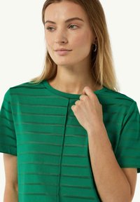 Green striped short-sleeve T-shirt with a round neckline and soft fabric. Features textured horizontal stripes for visual interest.