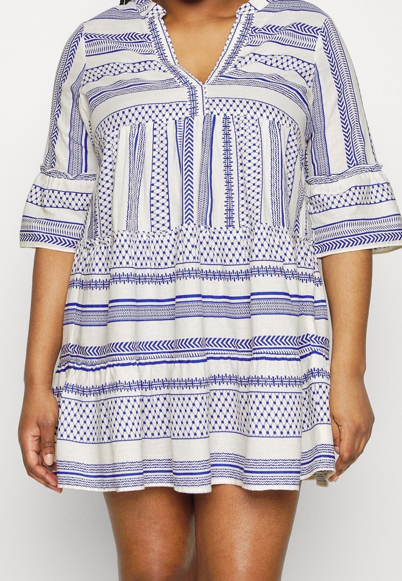 Blå och vit randig klänning med V-ringning, utsvängda ärmar och en utsvängd kjol, med geometriska mönster och texturerad tyg.