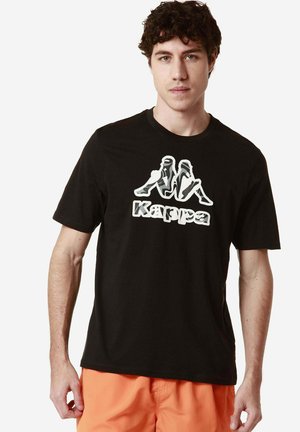 T-shirt di cotone nera con un design grafico di figure e il nome del marchio "Kappa" in bianco. Maniche corte e scollatura rotonda.