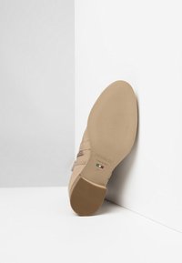 Scarpa in pelle beige con suola testurizzata, caratterizzata da un sottile dettaglio a strappo; fondo etichettato "NeroGiardini", "FABBRICATO IN ITALIA", taglia 37.
