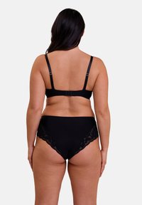 Ensemble de lingerie noire comprenant un soutien-gorge avec bretelles ajustables et fermeture à crochet, accompagné de culottes taille haute avec des bordures en dentelle sur les côtés.