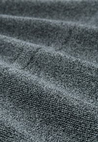 Grauer, strukturierter Stoff mit einem gewebten Muster, das sanfte, subtile Rillen und unterschiedliche Grautöne auf der gesamten Oberfläche zeigt.