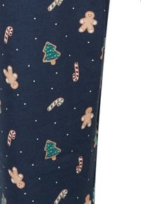 Marineblauwe stof met kleurrijke kerstthema-patronen: peperkoekmannetjes, zuurstokken en bomen, met witte spikkels erdoorheen.