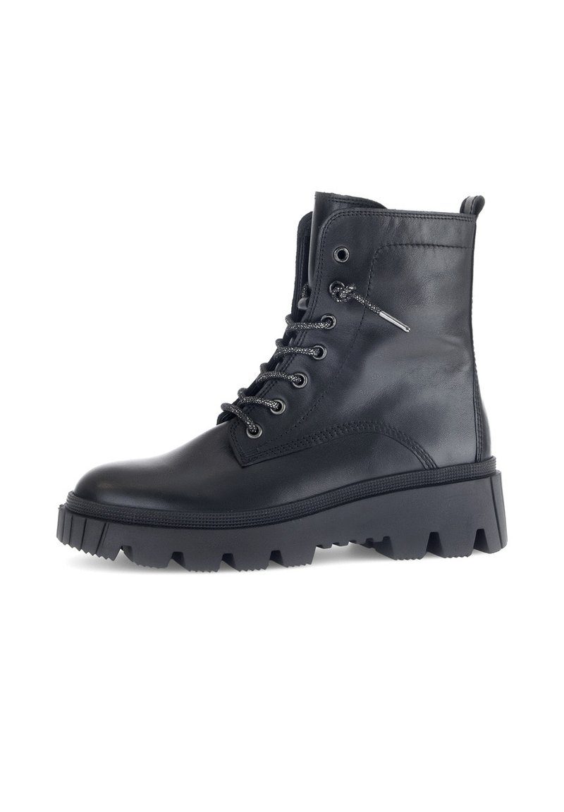 Botte chelsea en cuir noir à lacets avec une semelle à crampons épaisse, bout rond, accents métalliques et col rembourré pour un confort supplémentaire.