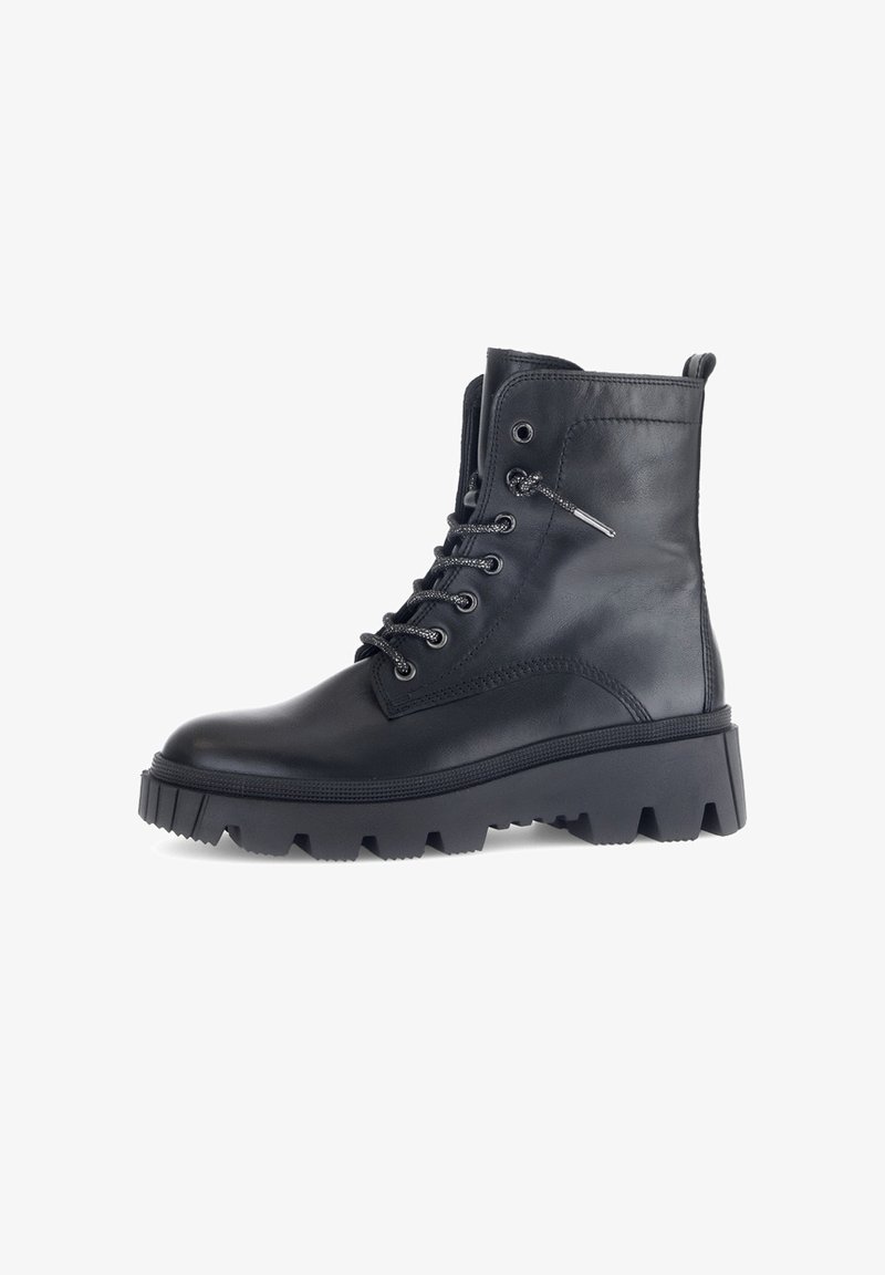 Botte chelsea en cuir noir à lacets avec une semelle à crampons épaisse, bout rond, accents métalliques et col rembourré pour un confort supplémentaire.
