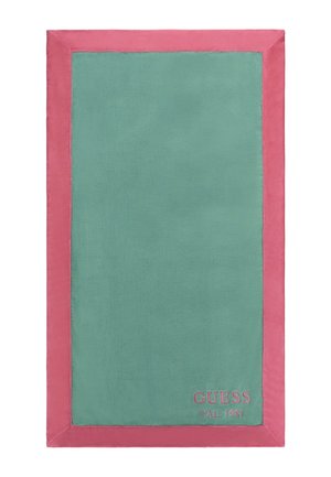 Asciugamano rettangolare con un centro verde e un bordo rosa. Realizzato in tessuto morbido con la scritta stampata "GUESS CAL 1981" nell'angolo in basso.