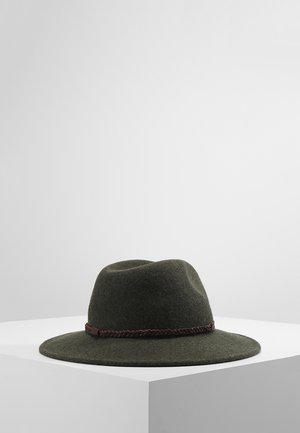 Donkergroene vilten hoed met brede rand en een gevlochten bruine leren band, tentoongesteld op een wit voetstuk tegen een grijze achtergrond.