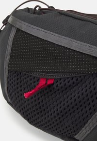 Bolso de cintura negro con tela de malla texturizada y transpirable, correa de acento roja, ribete reflectante y un diseño elegante y contorneado.