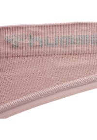 Helle pinke Sportkopfbinde aus geripptem Stoff, mit einem grauen Logo, das auf der Vorderseite gestickt ist, und einer glatten Verarbeitung entlang der Kanten.