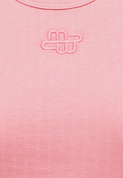 Ροζ ριμπ μπλουζάκι με λουράκια, με υφασμάτινο ανάγλυφο λογότυπο στο κέντρο. Η λαιμόκοψη είναι στρογγυλεμένη και το ύφασμα φαίνεται λείο.