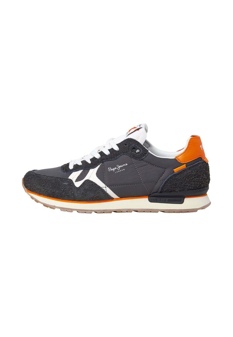 Zapatilla gris y negra con acentos blancos, con un upper texturizado, detalles naranjas en el talón y una suela de goma.