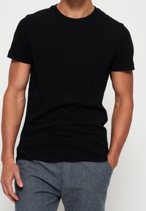 T-shirt noir à col rond en coton. Coupe ajustée avec manches courtes, avec un discret logo sur la poitrine. Texture lisse.