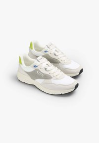 Scarpe da ginnastica bianche con accenti in suede grigi, una superficie testurizzata, linguette sul tallone verdi e una suola bianca spessa, dotate di lacci e dettagli con logo.