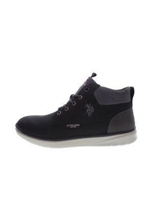 Deportiva alta negra con cuello acolchado gris, suela blanca, cordones y logo de U.S. Polo Assn. en el lateral y en la lengüeta.