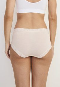 Jasnoróżowe majtki z wysokim stanem wykonane z miękkiego materiału, z koronkowym wykończeniem wzdłuż pasa i otworów na nogi. Gładka tekstura.