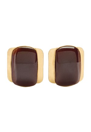 Para złotych kolczyków w kształcie kwadratu z zaokrąglonym, ciemnobrązowym, błyszczącym kamieniem na środku, na białym tle.