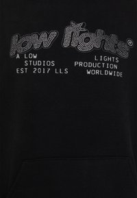 Sweat à capuche noir avec inscription en strass argenté : « low lights » et détails supplémentaires sur le studio et la production, avec une poche avant.